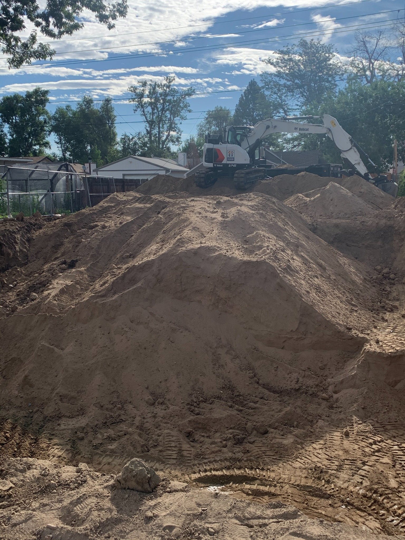 Excavator working through a residential site cut
