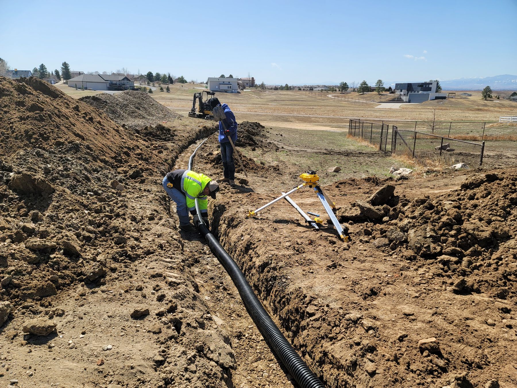 Crew laying drainage pipe on a residential lot