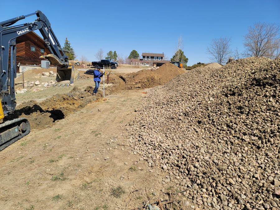 Compact excavation with a gravel bed prepared for pipe installation.