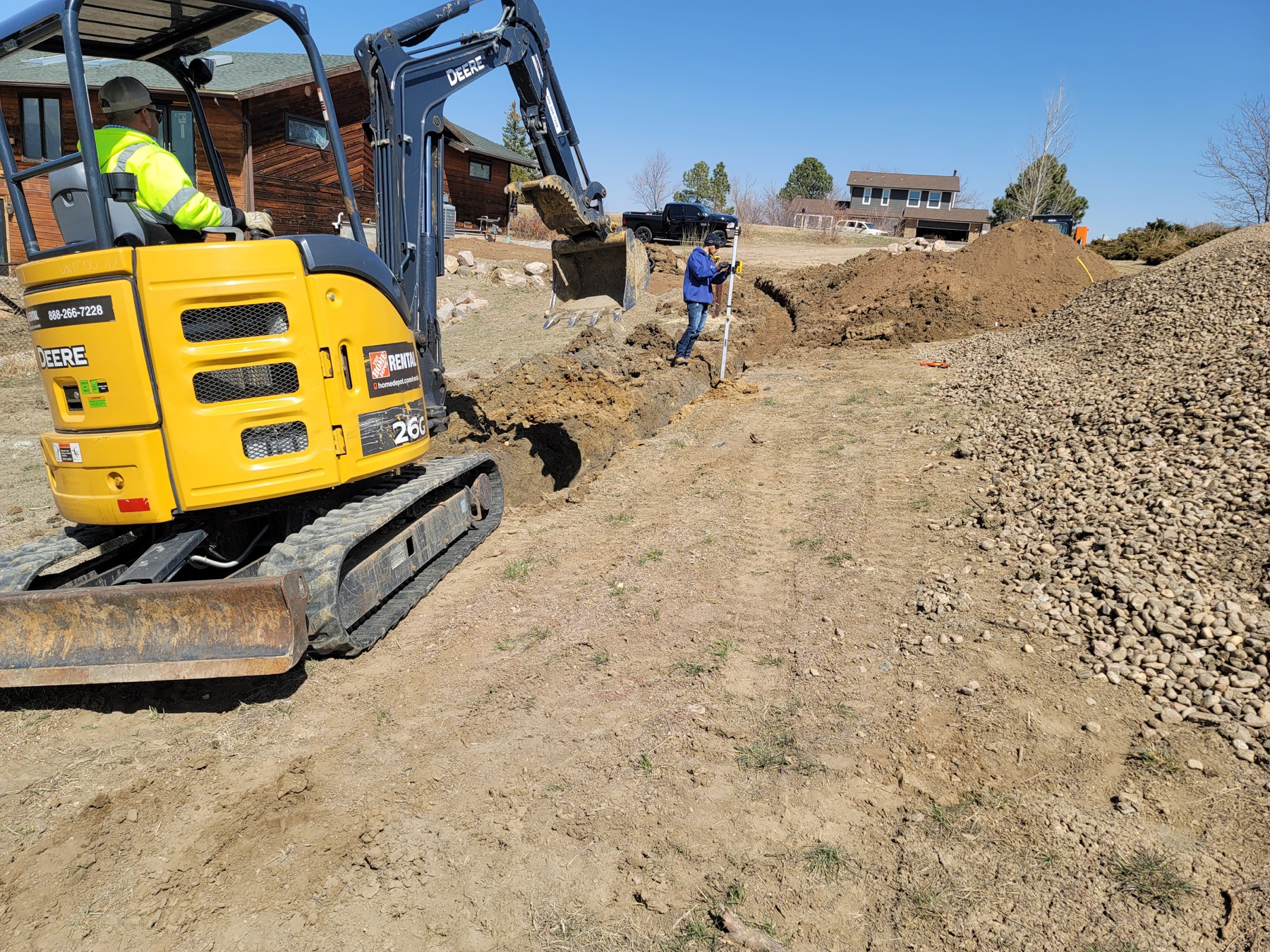 Excavator operator completing residential dirt work